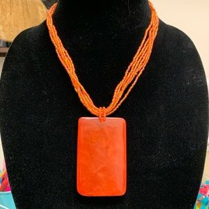 Orange beaded necklace with lucite square pendant